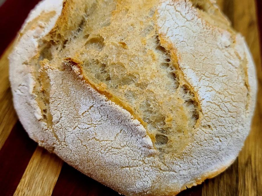 Whole artisan country boule on a wooden board